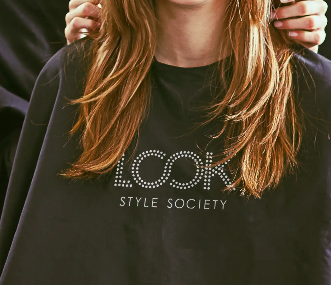 Close up of Look Style Society logo on black salon apron.